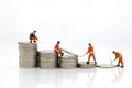 Miniature people: Worker working on stack of coins, income from work. Image use for business concept Royalty Free Stock Photo