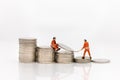 Miniature people: Worker working on stack of coins, income from work. Image use for business concept Royalty Free Stock Photo