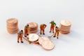 Miniature people: Worker working on stack of coins, income from work. Image use for business concept Royalty Free Stock Photo