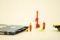 Miniature people: Workers moving circuit board for repair