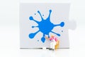 Miniature people: Workers are painting color on the puzzle. Image use for business concept