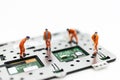 Miniature people: Workers repairing circuit board ,electronics repair. Use image for support and maintenance business