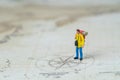 Miniature people young man backpacker standing on vintage world Royalty Free Stock Photo