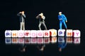 Miniature Photographers taking pictures behind a Group Of Letters forming Word Spelling