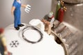 Miniature Plumbers Repairing A Thermostat