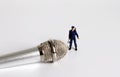 A miniature police officer standing in front of a microphone.