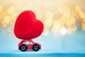 Miniature red car carrying a red heart on shine bokeh background Royalty Free Stock Photo