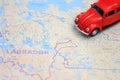 Miniature red car driving on a map of Labrador canada