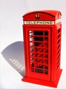 Miniature red English phone box with shadow on white background Royalty Free Stock Photo