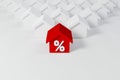 Miniature red roof house with percent icon among white houses for real estate property industry