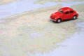 Miniature red car driving on a map of Nova Scotia canada