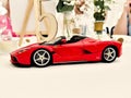 Miniature red toy Ferrari car on a tabletop