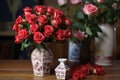miniature roses in a white ceramic vase next to a box with shipping labels