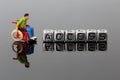 Miniature scale model man in a wheelchair with the word access on beads