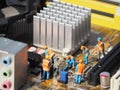 Miniature scene of electrical engineer at motherboard.