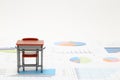 Miniature school study desk and documents with charts and graphs.