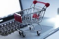 Miniature shopping cart on the keyboard of laptop computer. Royalty Free Stock Photo