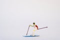 Miniature Skier In Action On A White Background - Copy Space