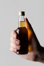 Miniature Spirits / Liquor Bottle Mock-Up - Male hands holding a liquor bottle on a gray background