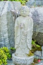 Miniature standing Buddha in garden