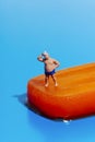 miniature sweating man on a melting orange popsicle