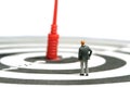 A businessman standing above dartboard with red arrow, thinking and measure the target goal Royalty Free Stock Photo