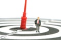 A businessman standing above dartboard with red arrow, thinking and measure the target goal Royalty Free Stock Photo