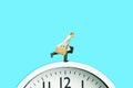 A businessman running above clock carrying briefcase. Isolated on blue background. Royalty Free Stock Photo