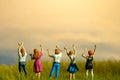 Miniature tiny people toys photography. Group of teens raised hand or hands up celebration at meadow land