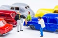 Miniature tiny toys photographer take photos man standing and woman sitting on car bonnet at the public car parking. Royalty Free Stock Photo