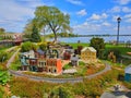 Miniature town surrounded by a mechanical train in a beautiful park in the summer.