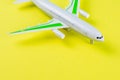 Miniature toy airplane on yellow background. Trip by airplane