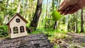 miniature toy house in forest and hand with watering can. natural background. symbol taking care of Eco Friendly home