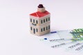 Miniature toy house model and euro banknote on white background. Royalty Free Stock Photo