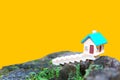 Miniature Toy House on a Tree Stump with a Bold Yellow Backdrop