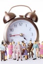 Miniature toy people stand near alarm clock Royalty Free Stock Photo