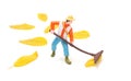 Miniature toy person raking foliage