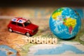 Miniature Toy vintage car and a world map balloon on a map.Travel and transport concept. Royalty Free Stock Photo