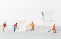 Miniature toy workers crash the ice for cold drinks. Royalty Free Stock Photo