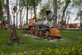 Miniature train model green with orange, garden ornament on summer day