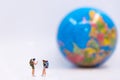 Miniature traveler and hiker backpack standing see the globe for the tourist and adventure around the world.