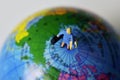 Miniature traveler woman on the top the world