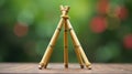 Miniature triangular bamboo structure with natural rope binding on wooden surface, set against a soft focus green background. Royalty Free Stock Photo
