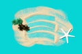 Miniature tropical island made of sand, toy palms and a sea star on a turquoise background