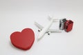 Miniature two suitcases, miniature toy airplane, and a red heart on white background. Royalty Free Stock Photo