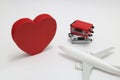 Miniature two suitcases, toy airplane, and a red heart on white background. Royalty Free Stock Photo