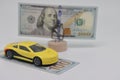 A miniature typewriter stands next to a banknote on a stand. Accurate financial calculation when buying a car. The concept of