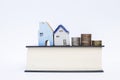 Miniature vintage house with stack of coin on think book isolate on white background Royalty Free Stock Photo