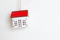 Miniature white toy house with red roof on a white background. Space for text.