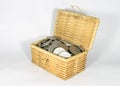 Miniature wicker chest filled with different coins on white background, saving money concept